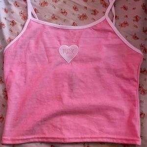 A cute crop top pastel pink has the f word on it.